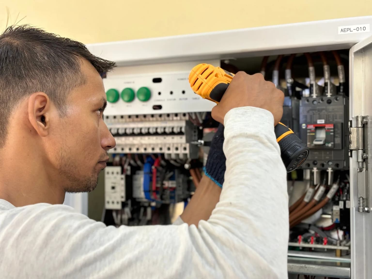 Electrician working on a large electrical distribution panel